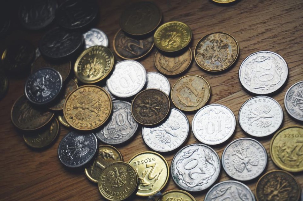 Coins beside an invoice, representing statutory interest and fixed compensation accruing on a late debt