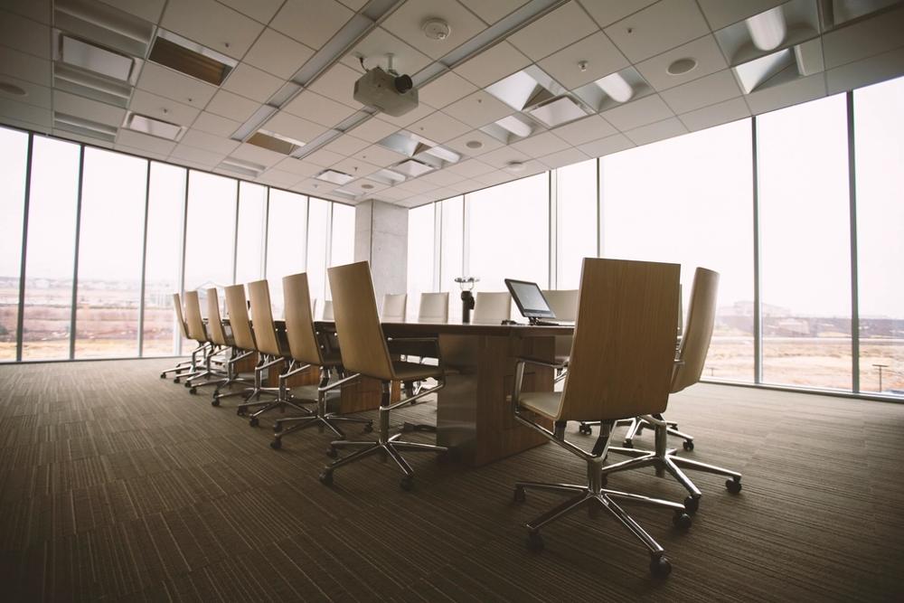 An empty boardroom table, representing the people with significant control behind a company